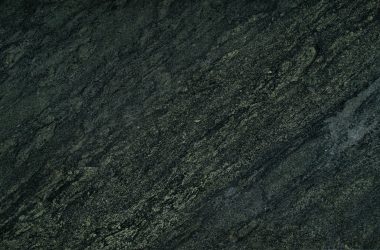Close-up of a dark stone surface showing rough texture and distinct patterns.