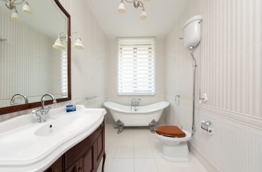Spacious bathroom featuring a classic clawfoot tub, vanity, and wooden toilet seat.