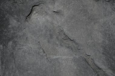Close-up of a textured gray stone surface, highlighting natural patterns and details.